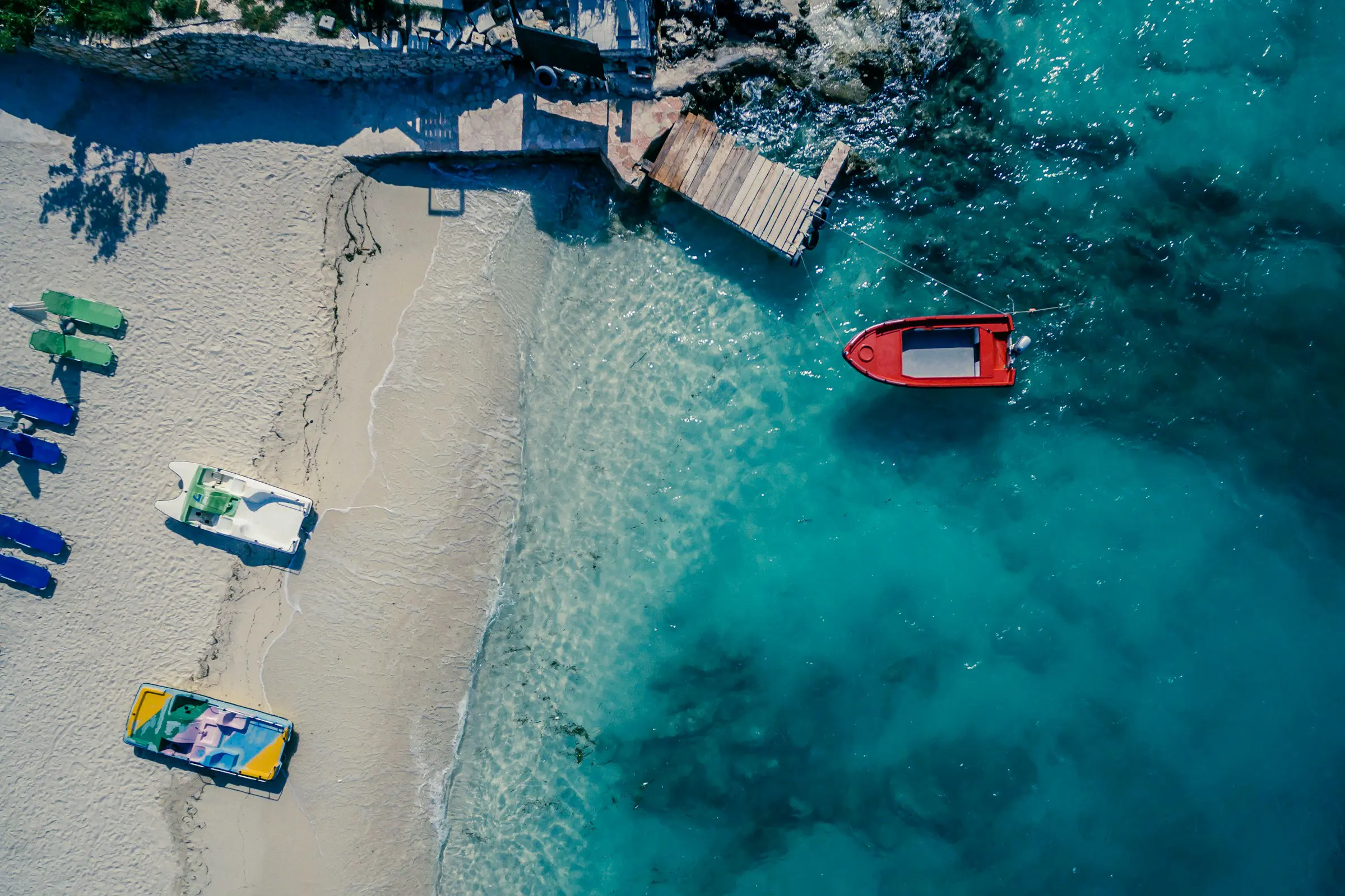 View from above on beach with small boats in blue sea