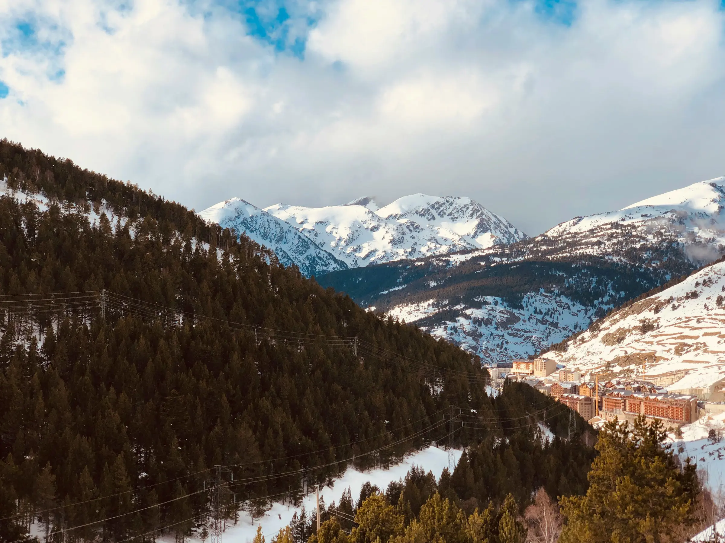 Utsikt over snødekte fjellkjeder i Grandvalira, Andorra, men et skianlegg nedenfor