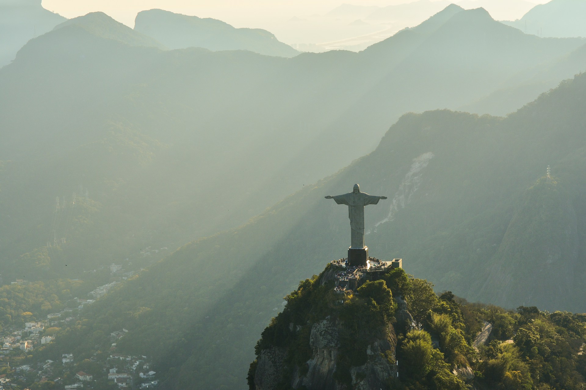 Kristusstatuen i Rio de Janeiro med fjellandskap i bakgrunnen, sett i solnedgang