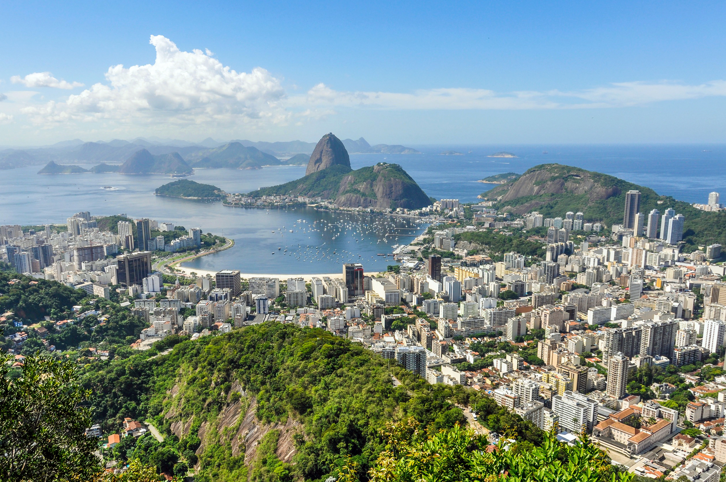 Utsikt over Rio de Janeiro med Sugarloaf-fjellet i bakgrunnen og den livlige byens skyline, omgitt av frodige fjell og det glitrende Atlanterhavet