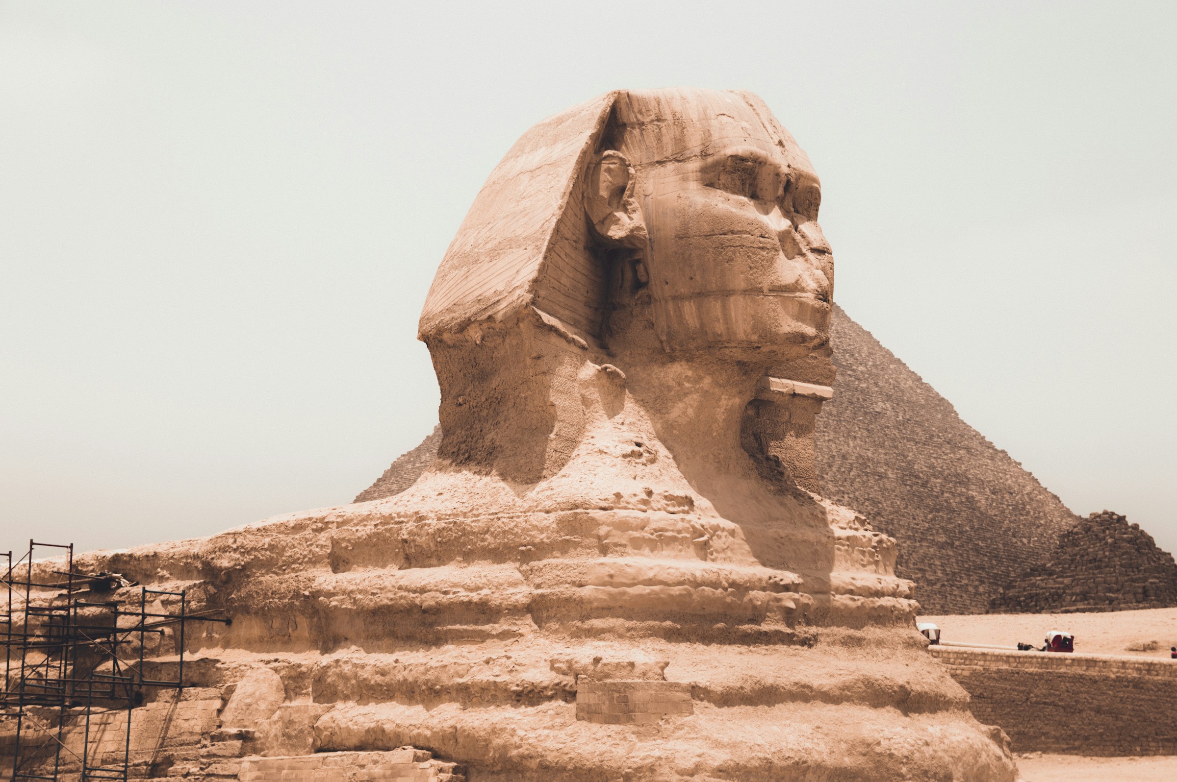 The Great Sphinx of Giza with the Pyramid of Khafre in the background under a clear sky in Egypt.