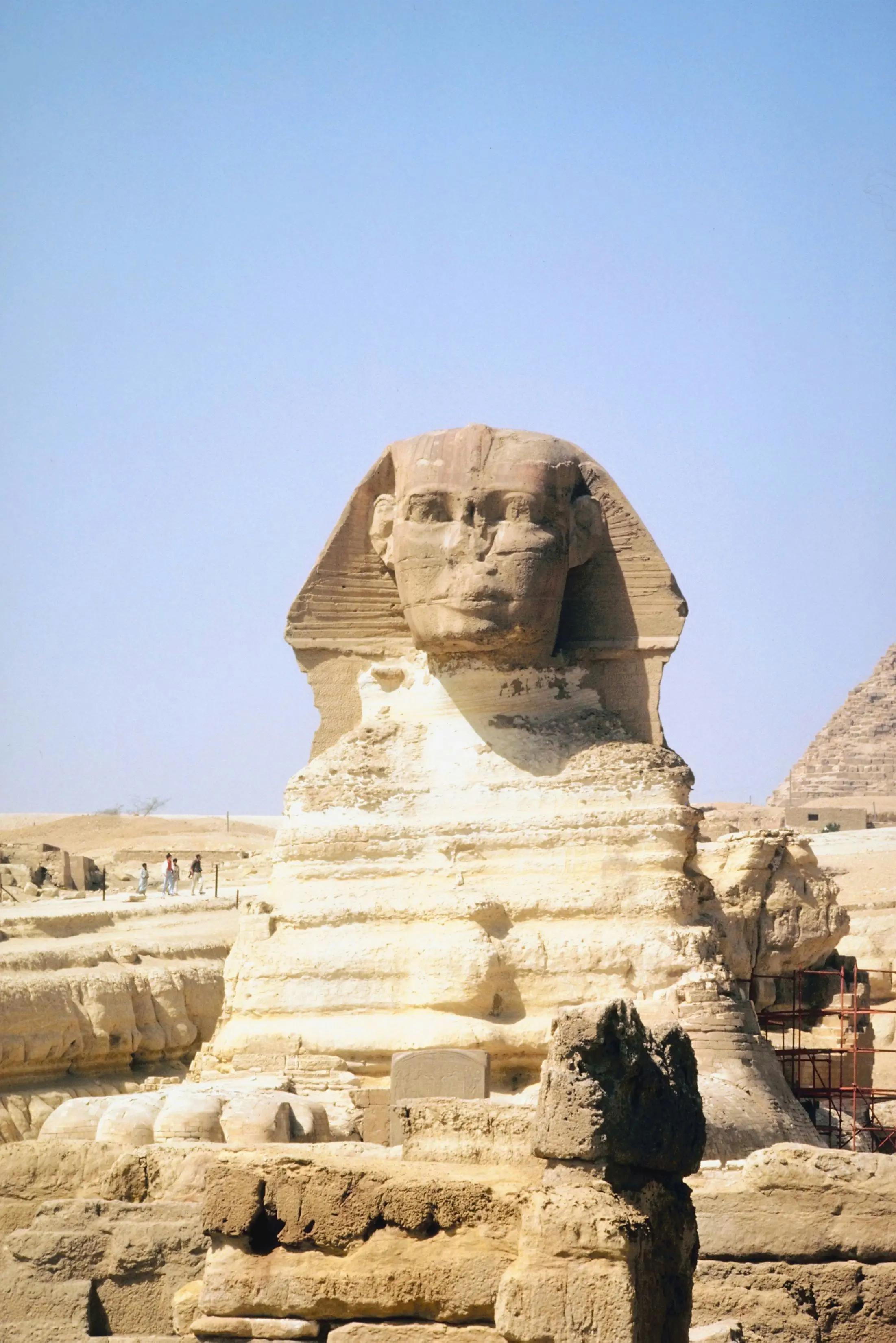 Sfinksen i Giza, et ikonisk monument i Egypt, med en blå himmel og pyramiden i bakgrunnen