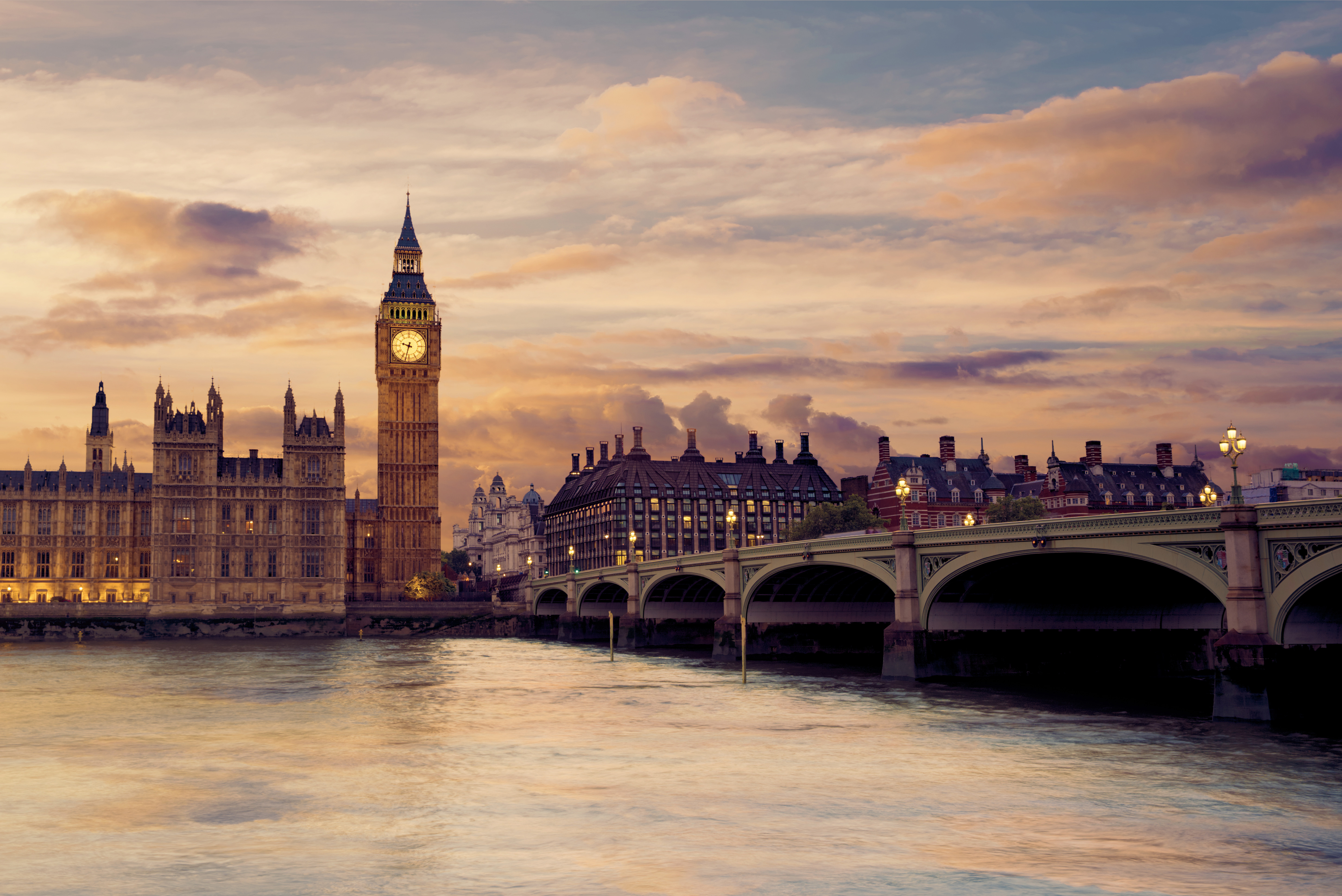 Big Ben og Houses of Parliament ved solnedgang, med Westminster Bridge over Themsen i London