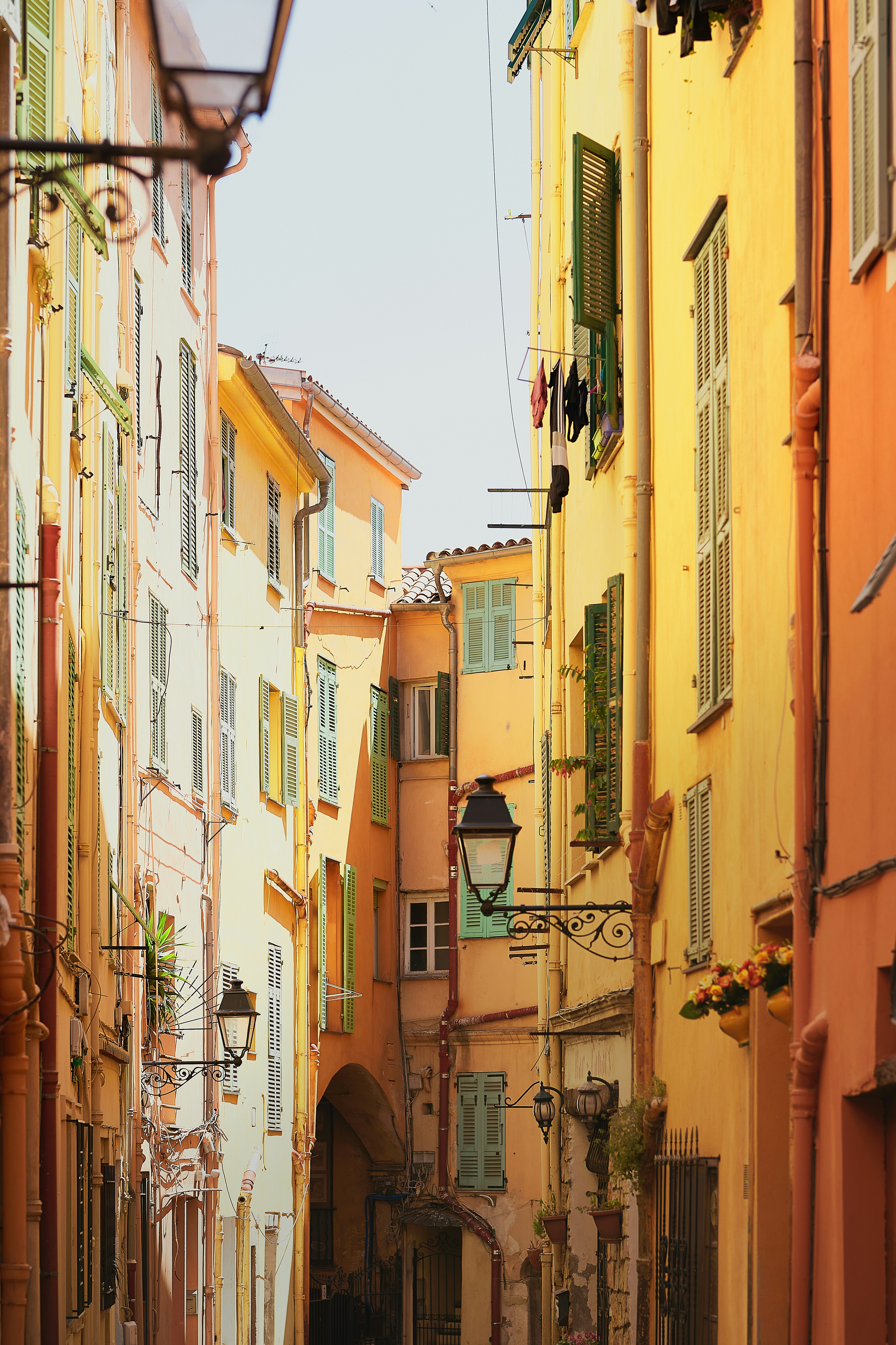 Fargerik, smal gate i en gammel europeisk by, med tradisjonelle skodder og utendørs belysning