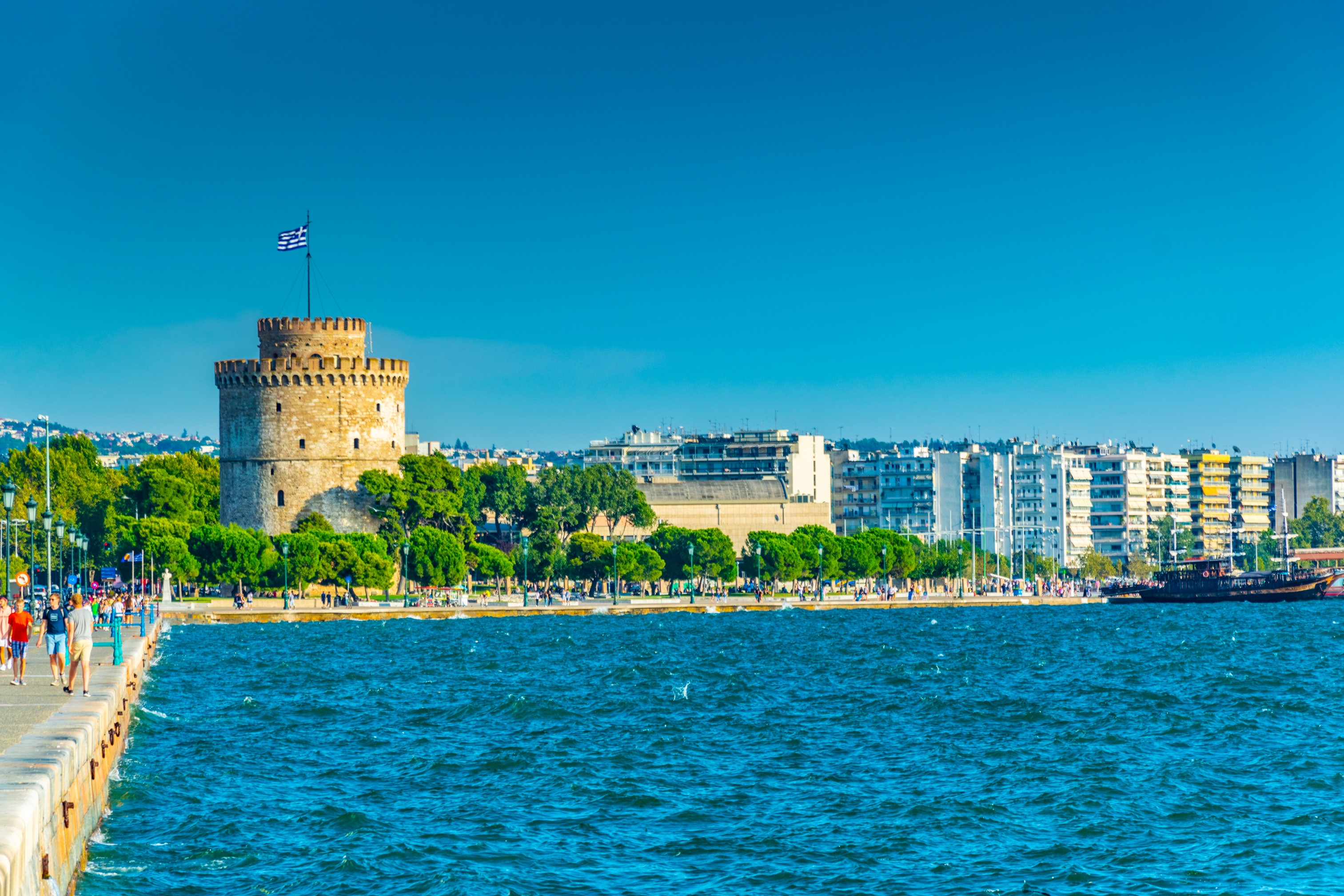 Utsikt over Det Hvite Tårn og havnepromenaden i Thessaloniki, Hellas, med blå himmel og Egeerhavet i forgrunnen