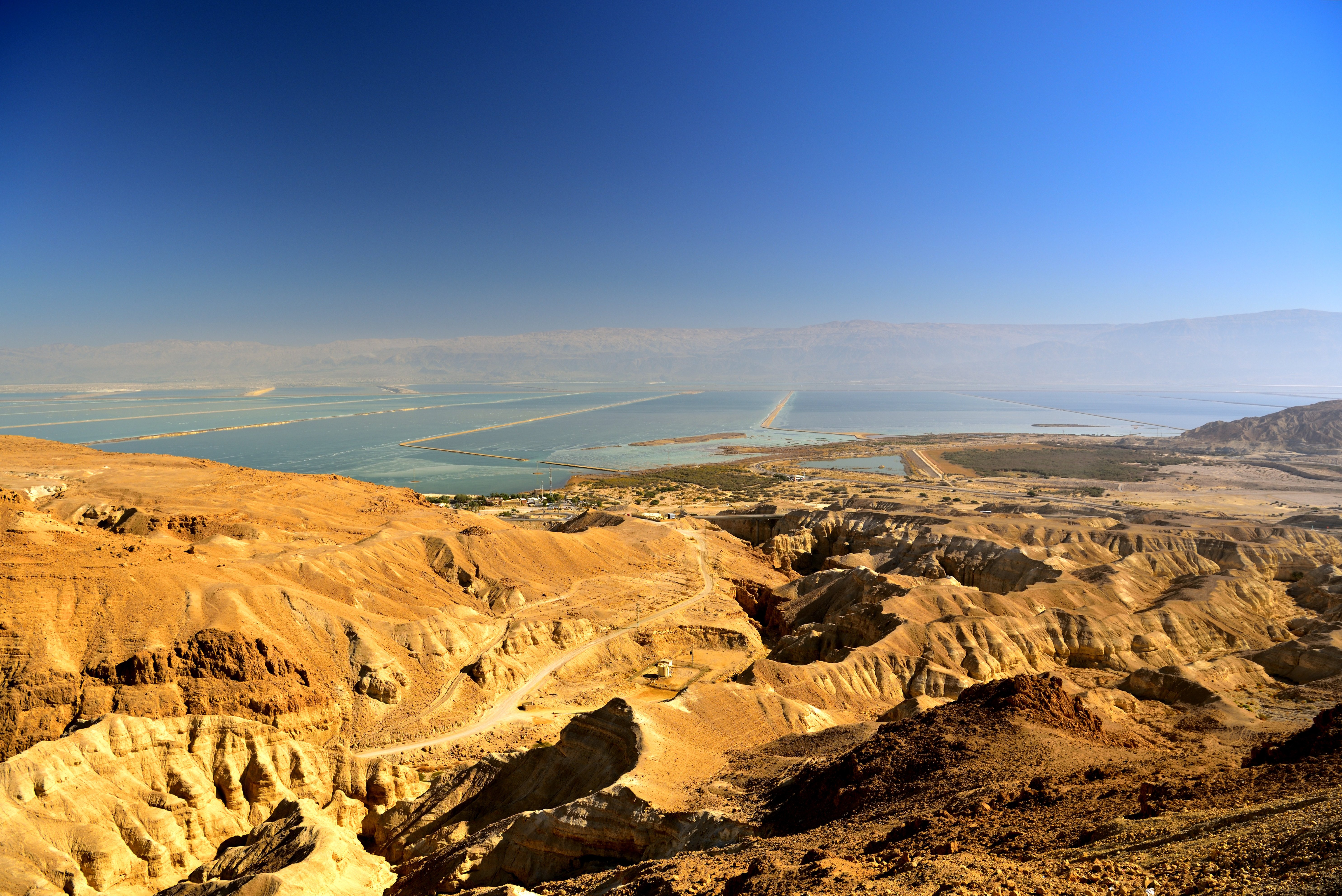 Travel to Israel - Sweeping view of the Dead Sea and surrounding desert landscape under a clear blue sky.