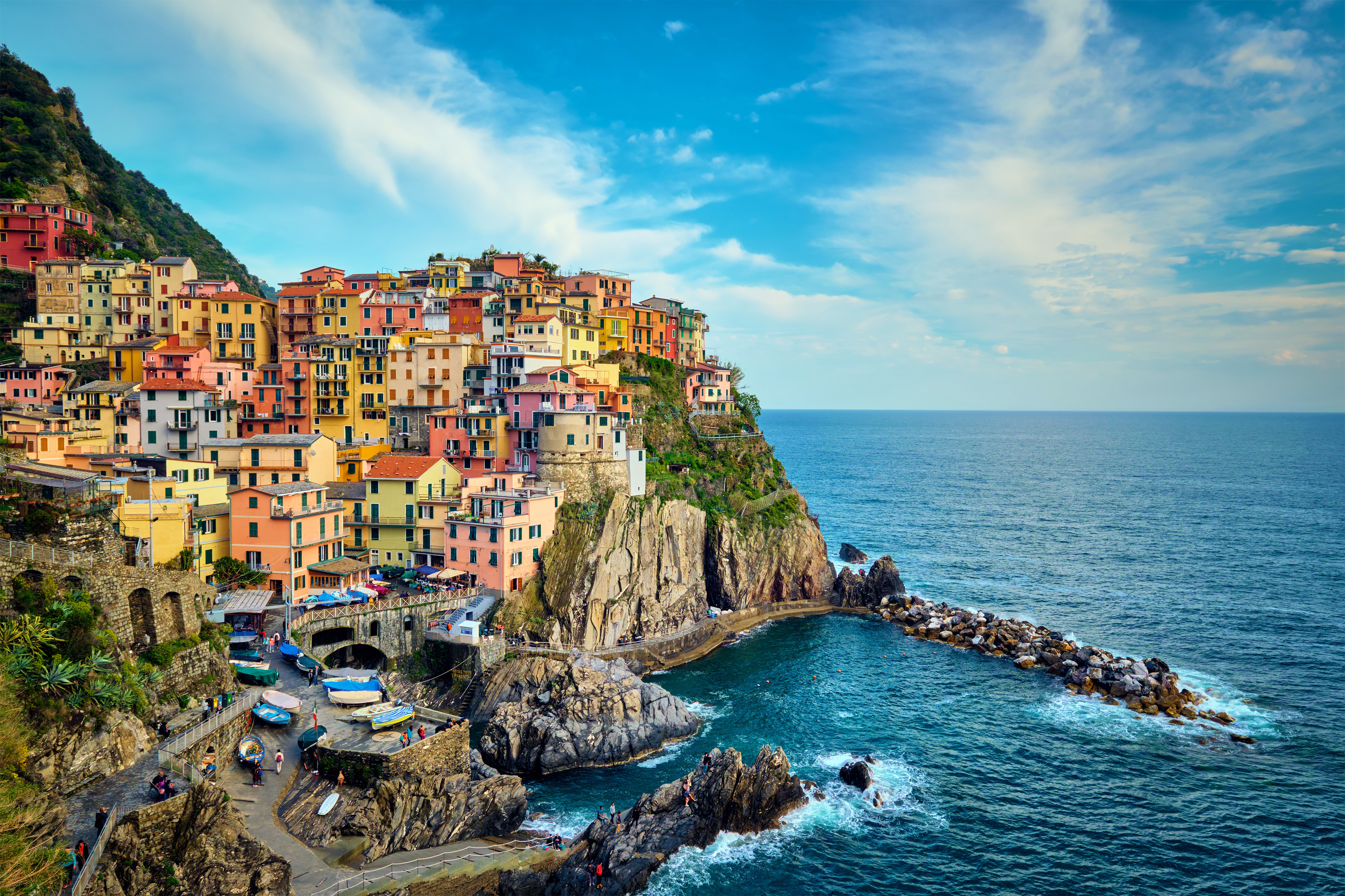 Fargerike bygninger i den pittoreske kystbyen Manarola, en del av Cinque Terre i Italia, med utsikt over det blå Middelhavet og dramatiske klipper