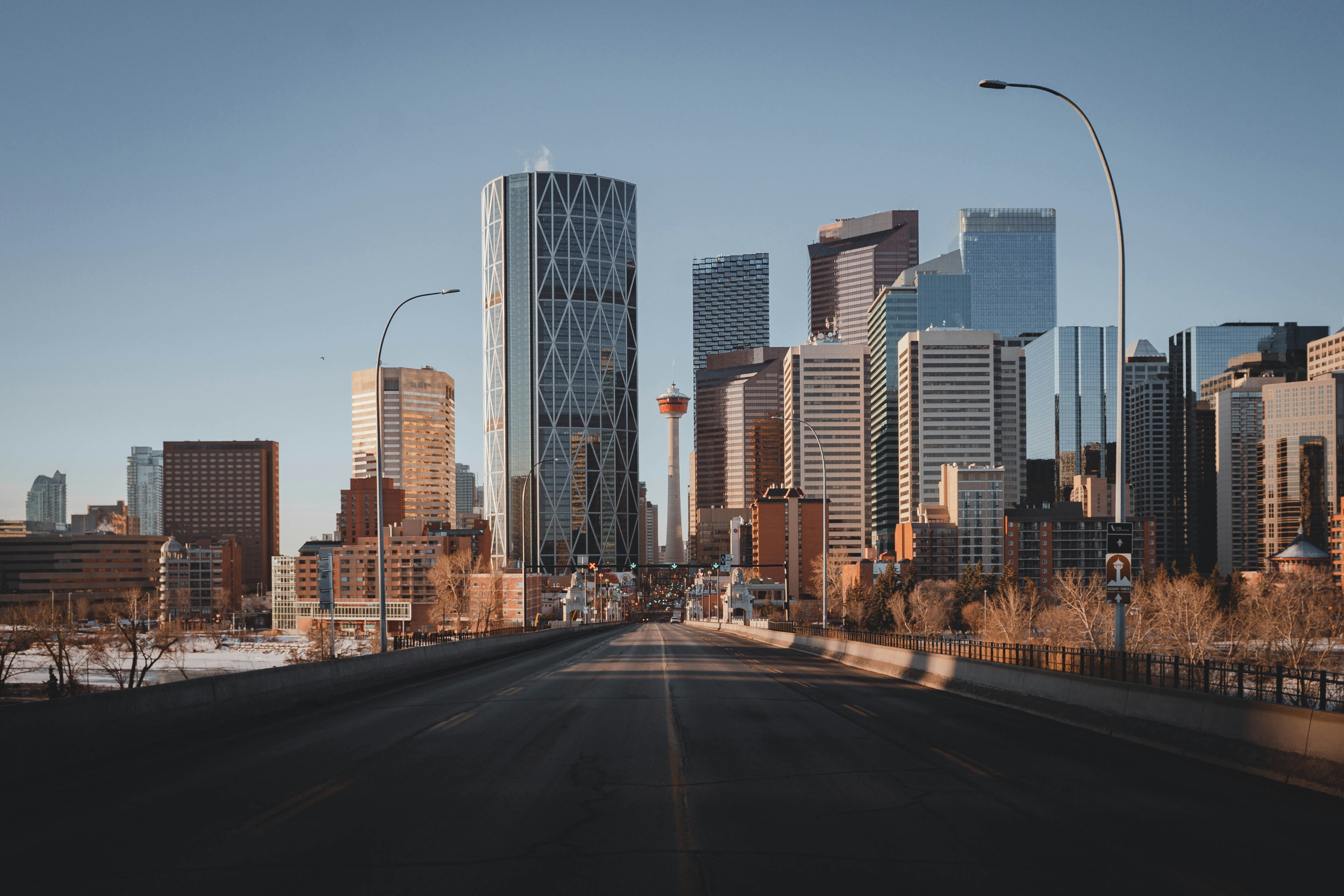 Skyline av Calgary sentrum med moderne skyskrapere og tårn i solnedgang. Klar blå himmel i bakgrunnen