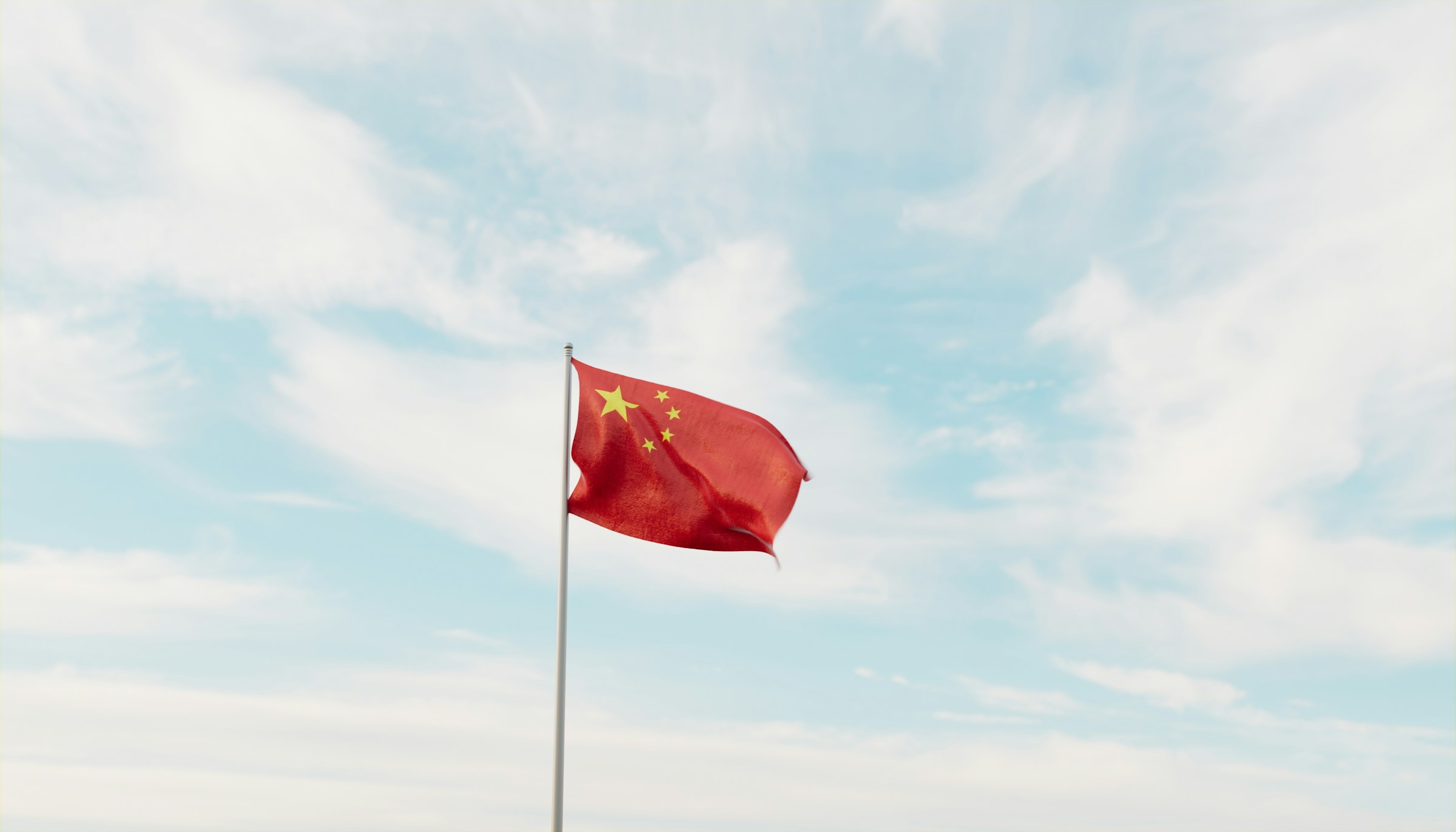 Chinese national flag waving against a clear blue sky