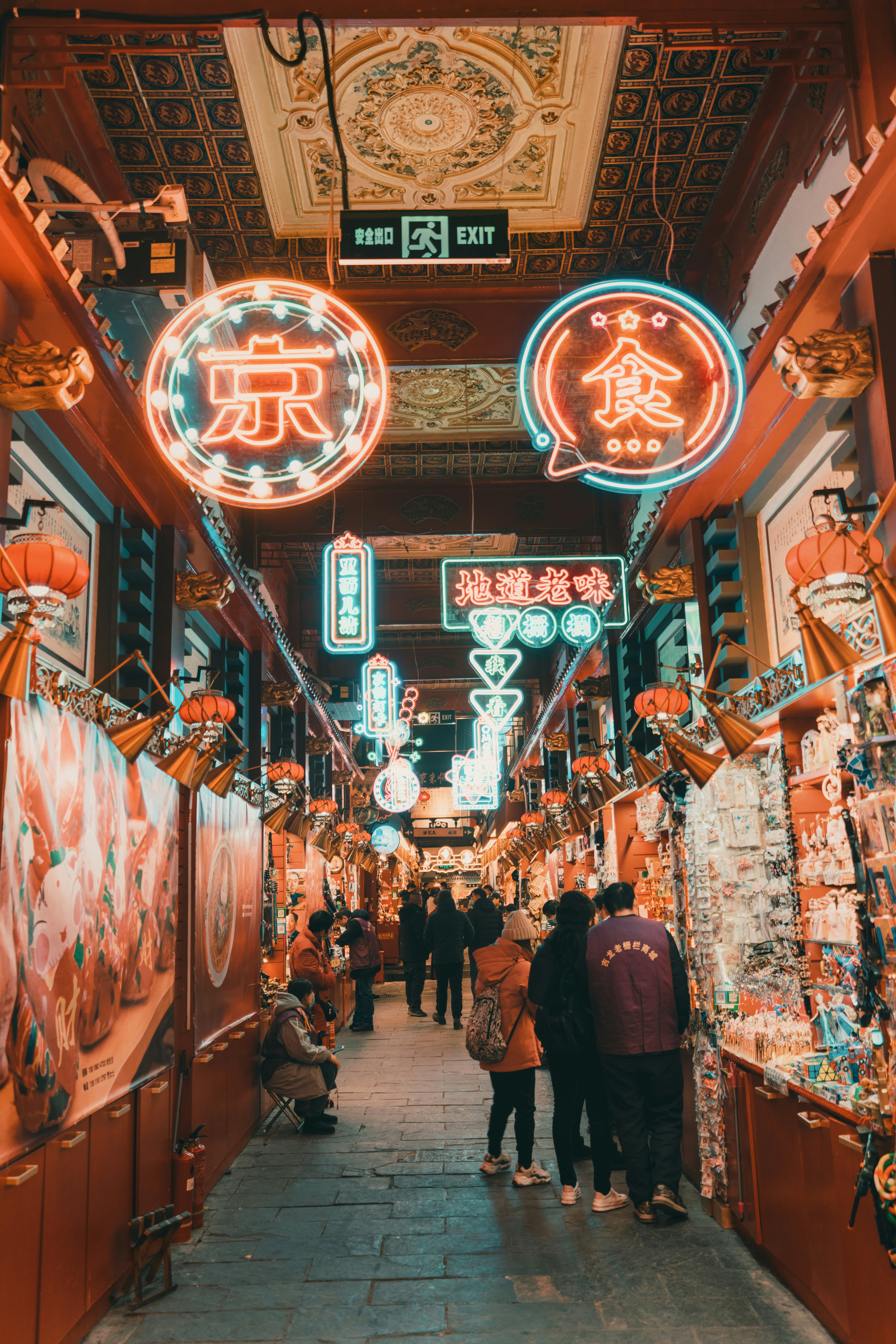 Folk som går gjennom et livlig gatemarked i Beijing om natten, opplyst av fargerike neonskilt og tradisjonelle dekorasjoner