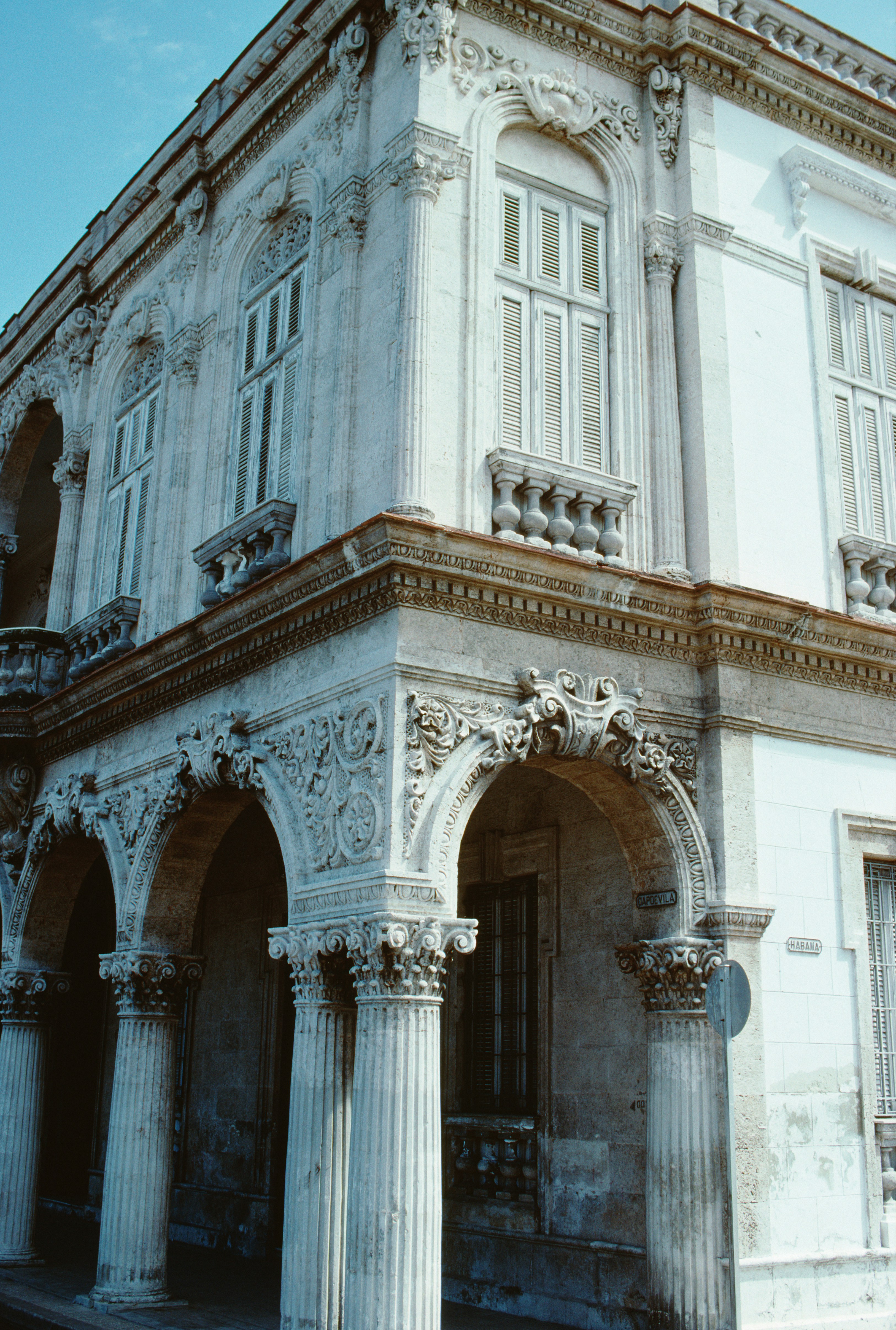 Historisk bygningsfasade med utsmykkede søyler og buer, med intrikate steinutskjæringer og klassiske arkitektoniske detaljer