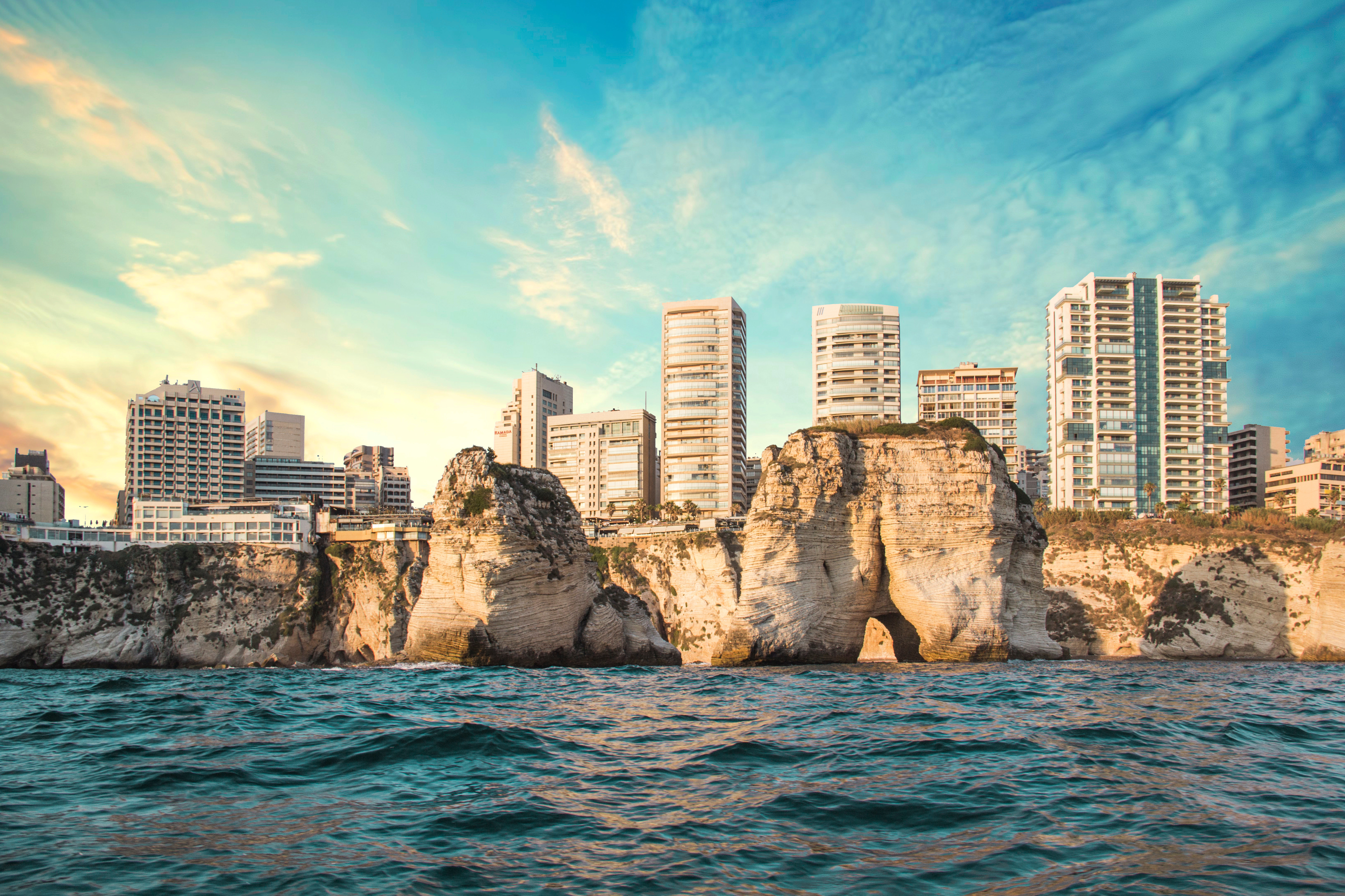 Seaside skyline of Beirut, Lebanon with Pigeon Rocks and modern buildings at sunset, viewed from the Mediterranean Sea