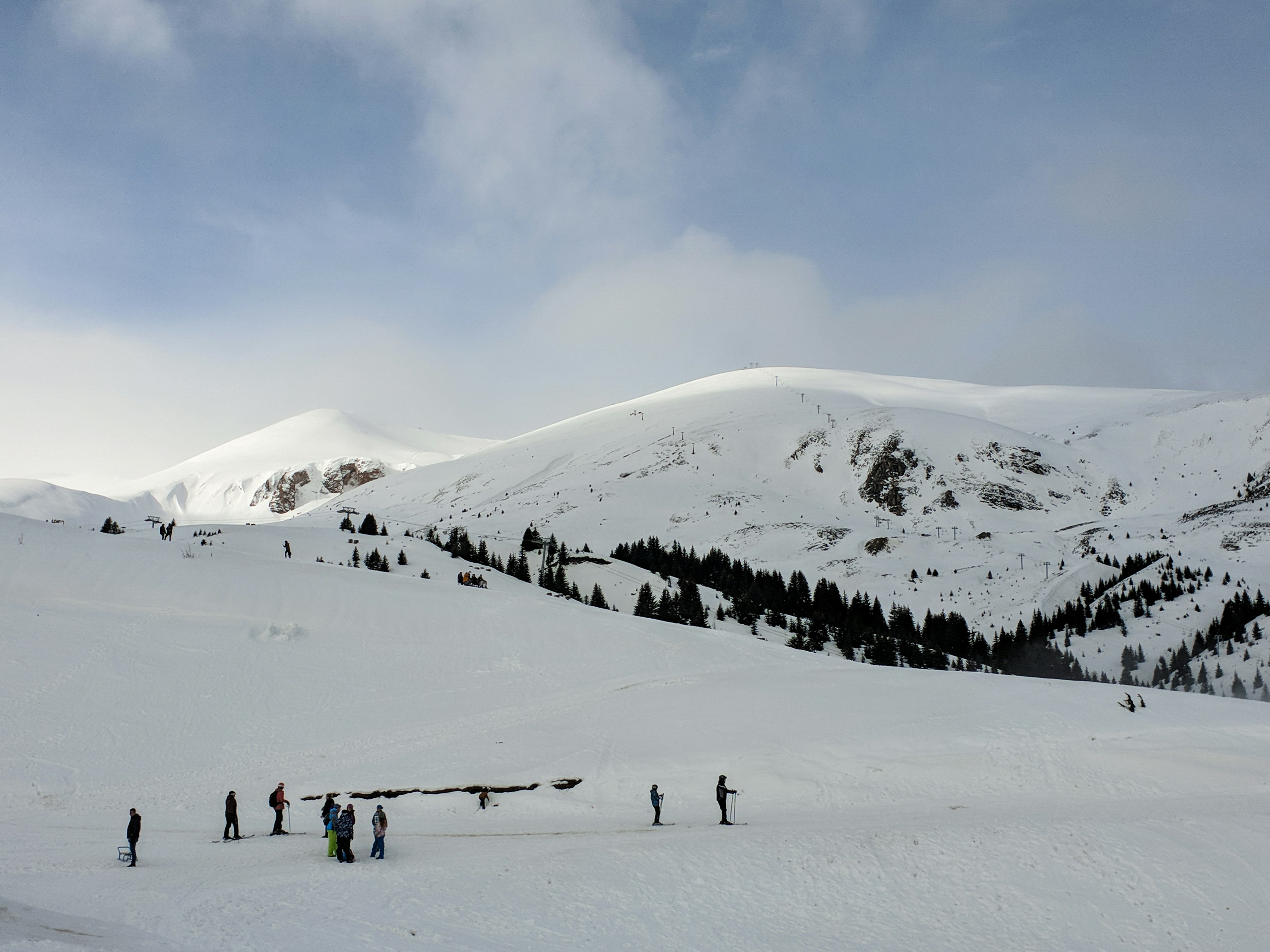 Reis til Popva Shapka - Snødekte skiløyper og vidder med fjell i bakgrunnen som møter blå himmel