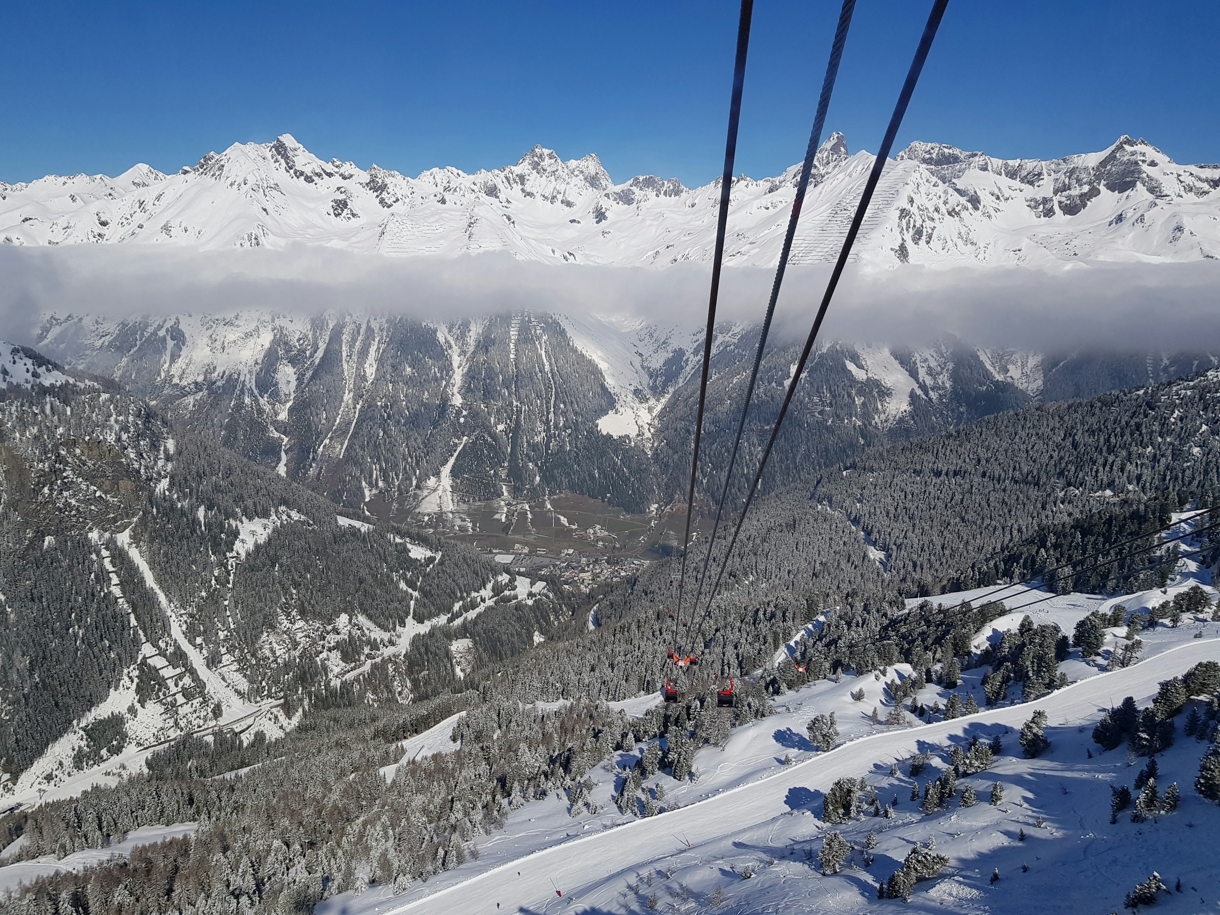 Utsikt over snødekte fjell og skiheis i Alpene, Ischgl med klar blå himmel