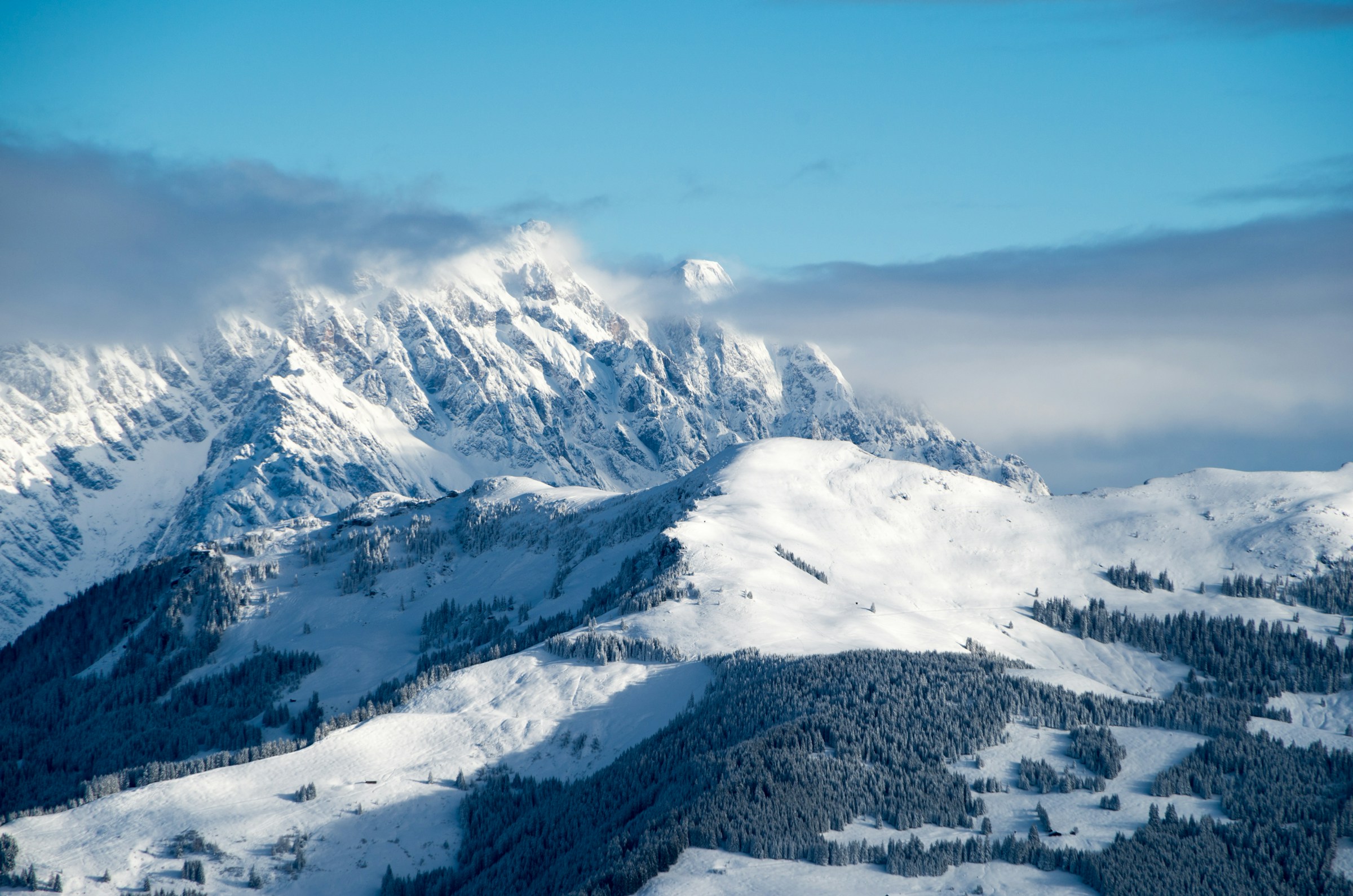 Snødekt vinterlandskap og fjell med blå himmel i bakgrunnen i skianlegget Zell am See, Østerrike