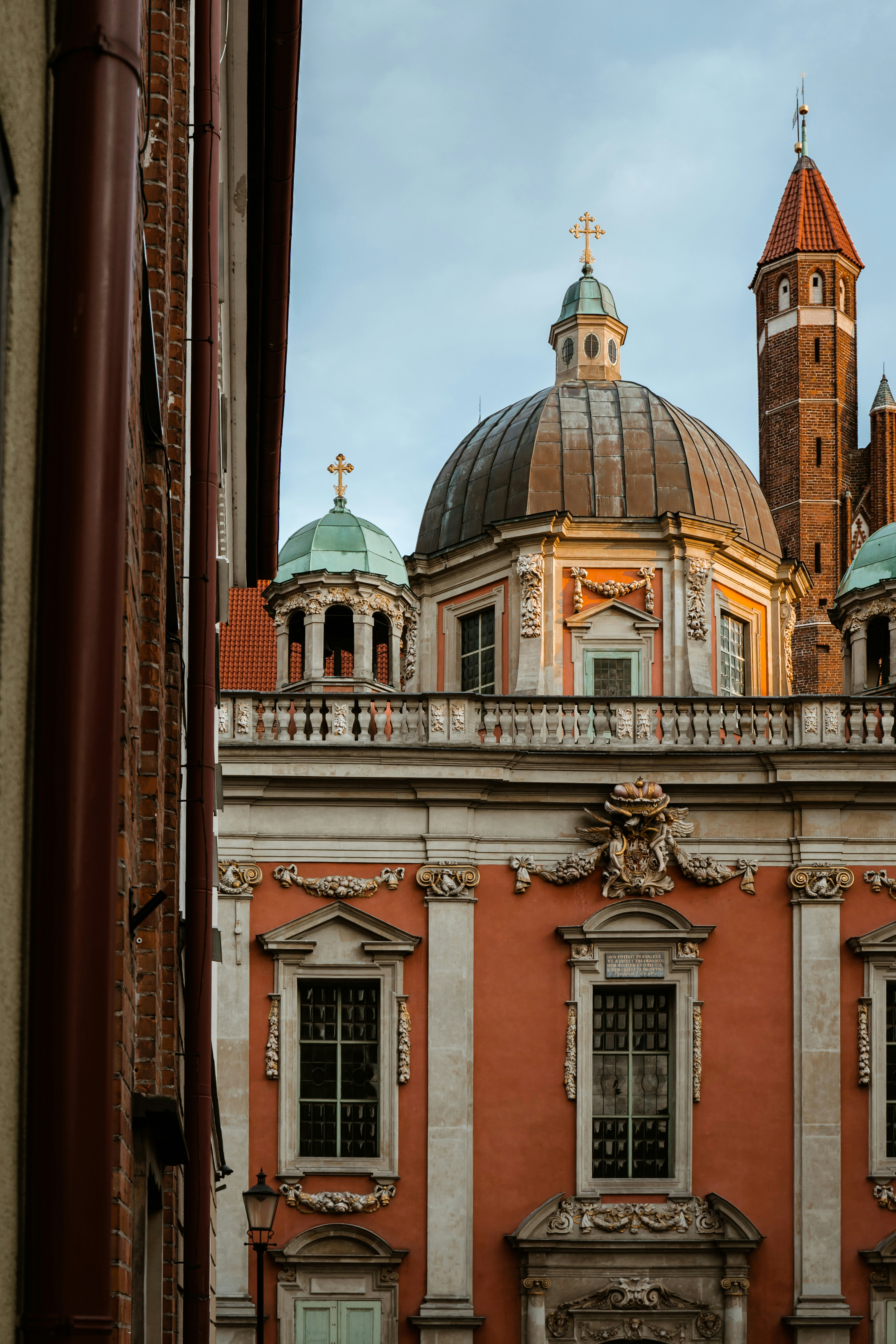 Historic Baroque church with ornate facade and dome, featuring intricate architectural details and cross adornments against a clear sky.