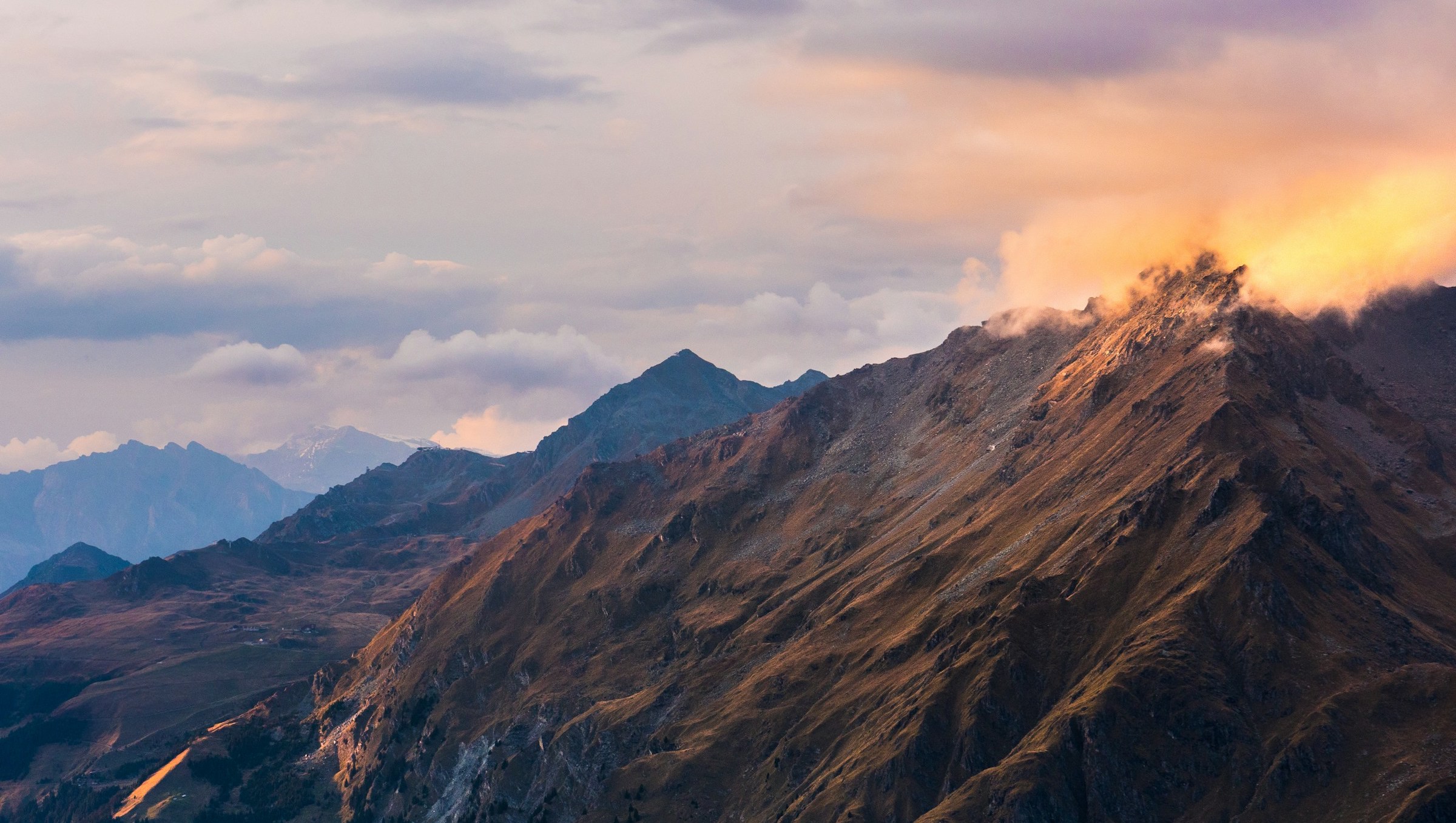 Mountain scenery at sunset with dramatic light and clouds over the mountain peaks of Verbier.