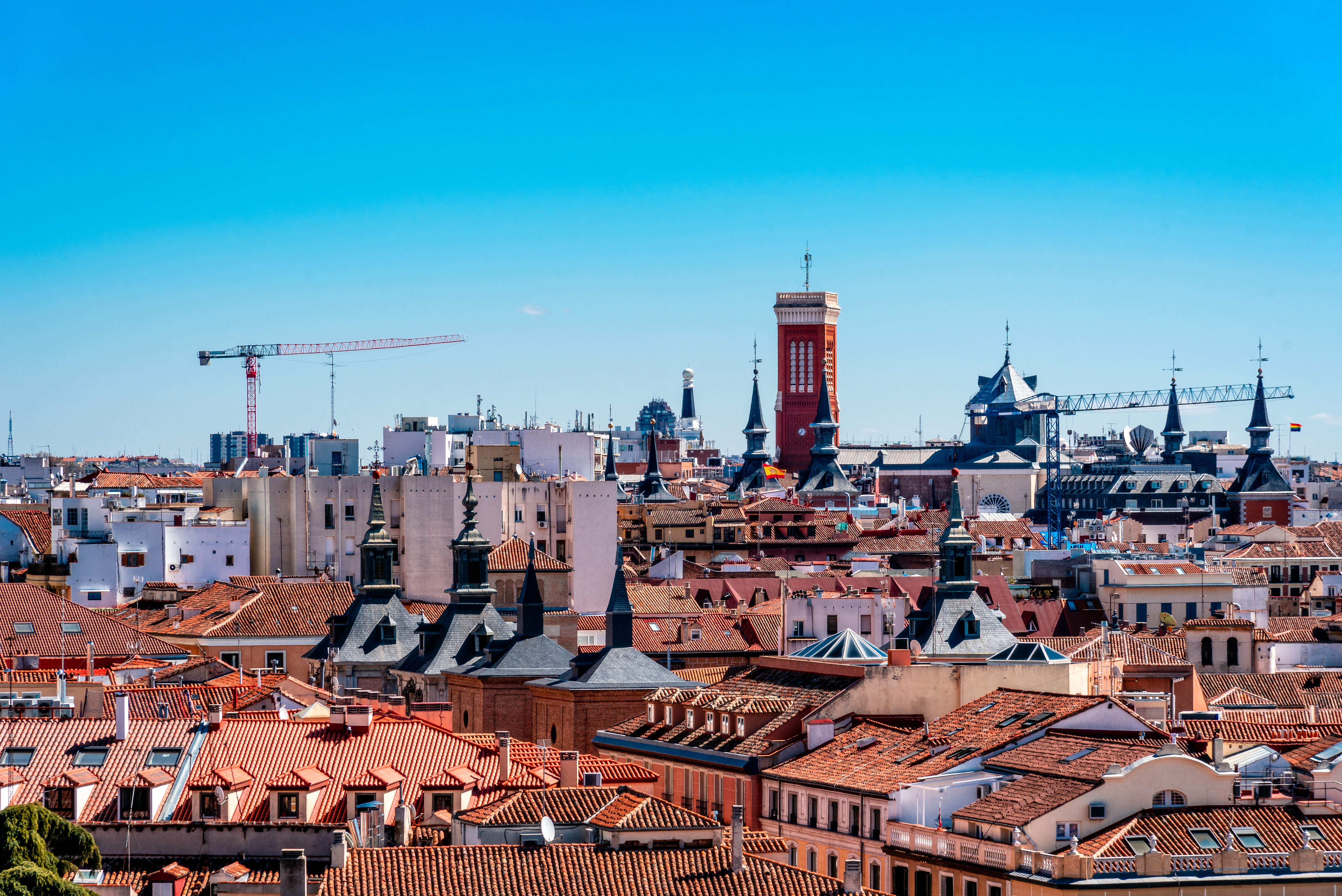 Scenic view of red rooftops and historic architecture in Madrid, Spain under a clear blue sky