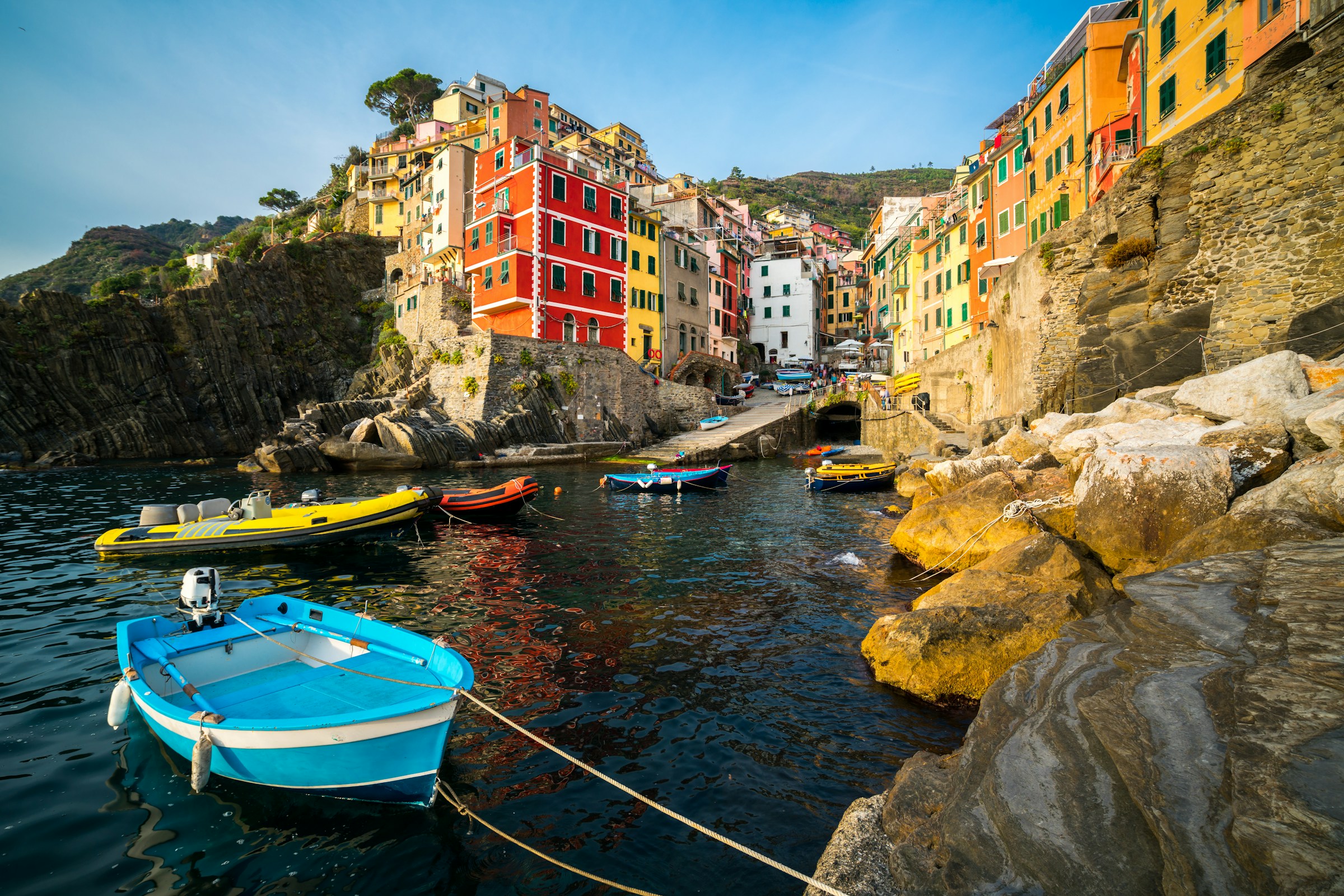 Colorful boats and buildings in the picturesque fishing village of Riomaggiore, part of Cinque Terre, Italy, on a sunny day