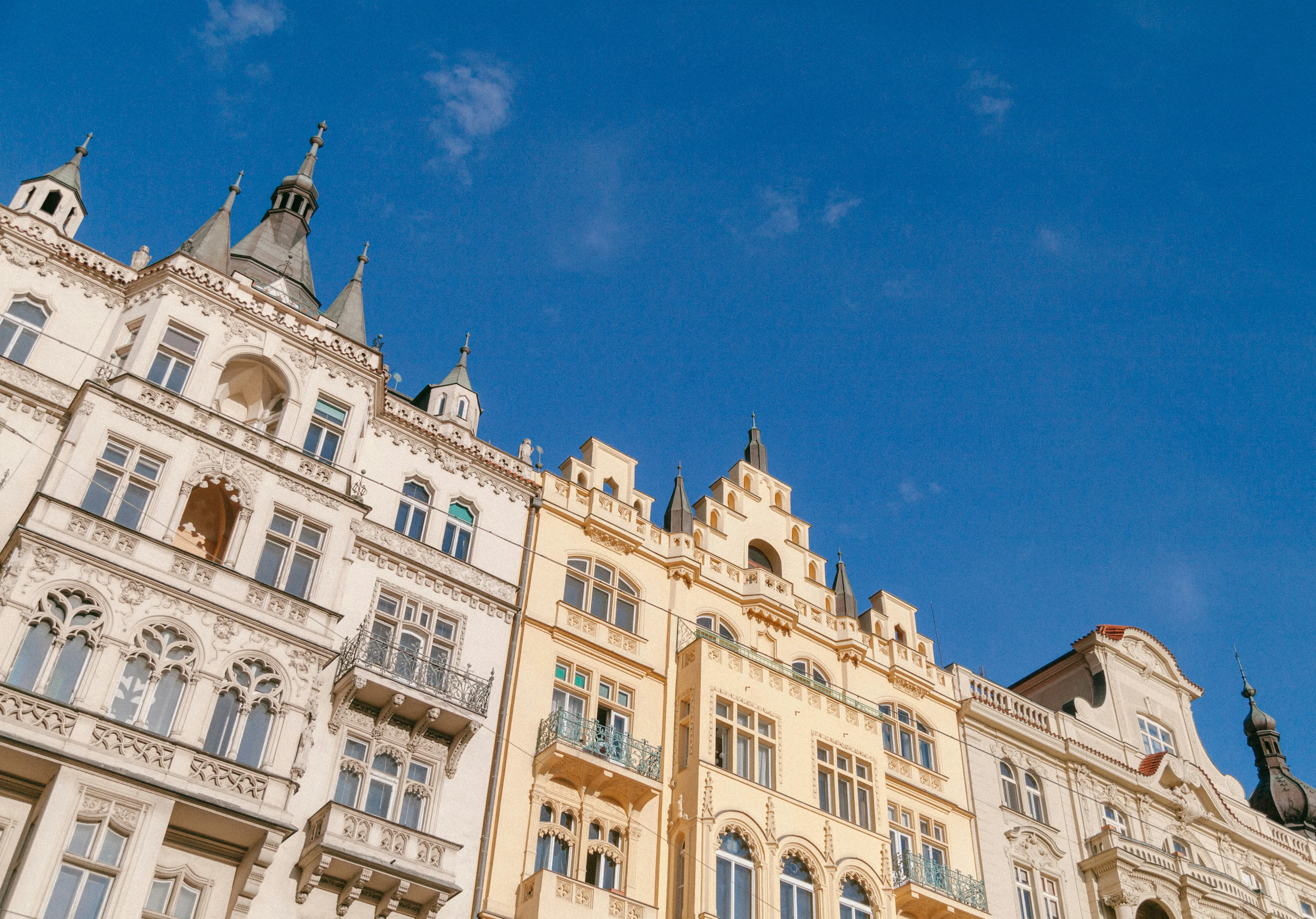 Historic European architecture against a clear blue sky featuring ornate facades and stylized spires