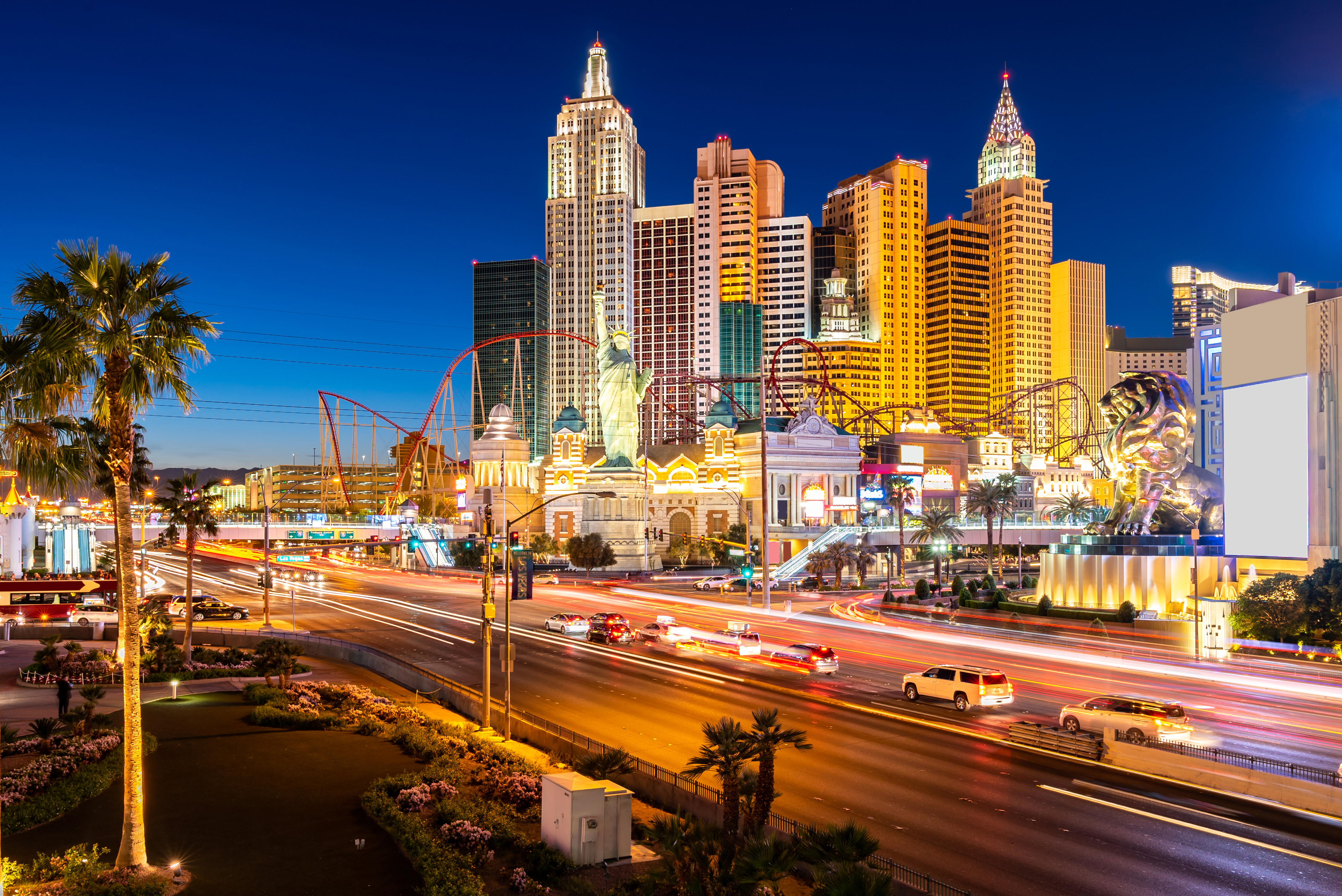 Las Vegas Strip om natten med opplyste hoteller, kasinoer og trafikk, samt en utsikt over ikonisk arkitektur og en livlig bysilhuett